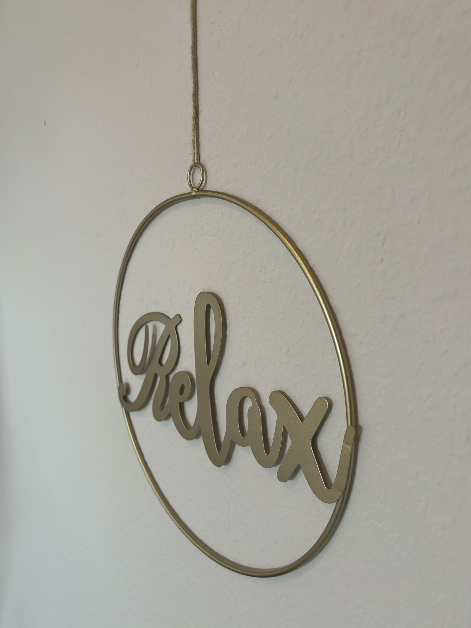 Ein Dekoring in gold mit der Beschriftung Relax