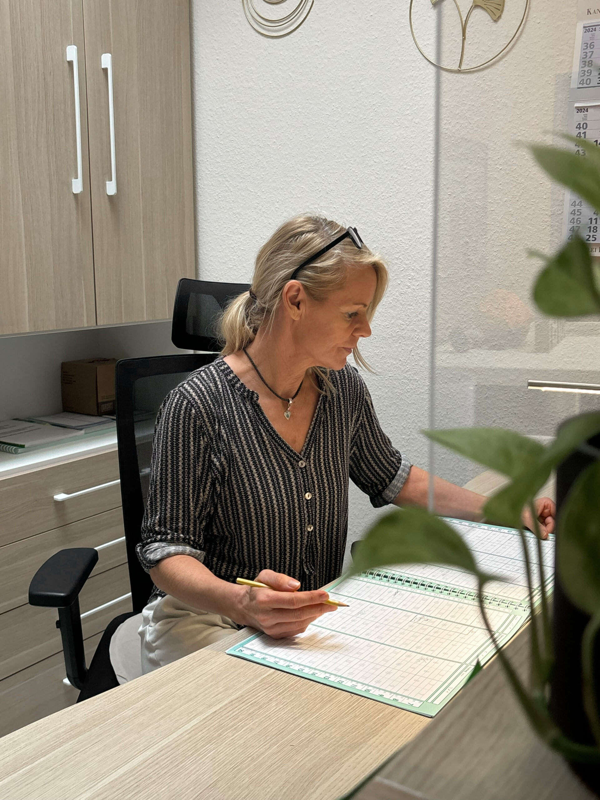 Inhaberin von Physio Ganster bei der Terminvergabe am Tresen